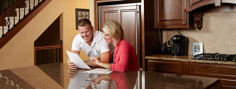 Couple happily reviews electricity bills that lowered since they replaced their HVAC system