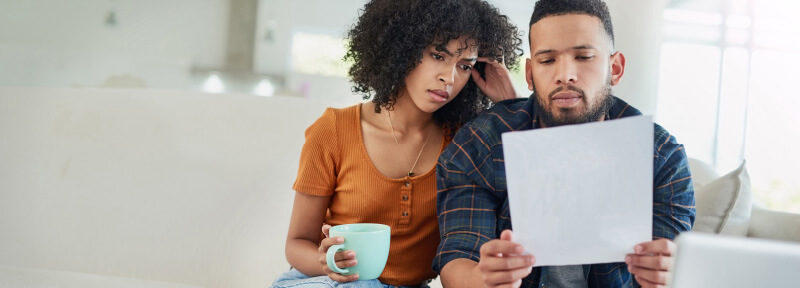 Couple Who Look Confused While Looking at Their Electric Bill