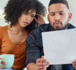 Couple Who Look Confused While Looking at Their Electric Bill