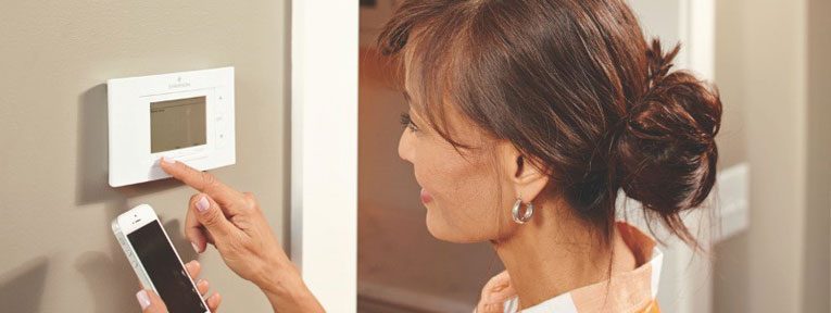 Women adjusting thermostat